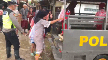 POLSEK LOSARI BANTU SISWA DAN WARGA LEWATI GENANGAN AIR ROB DI DESA PRAPAG LOR